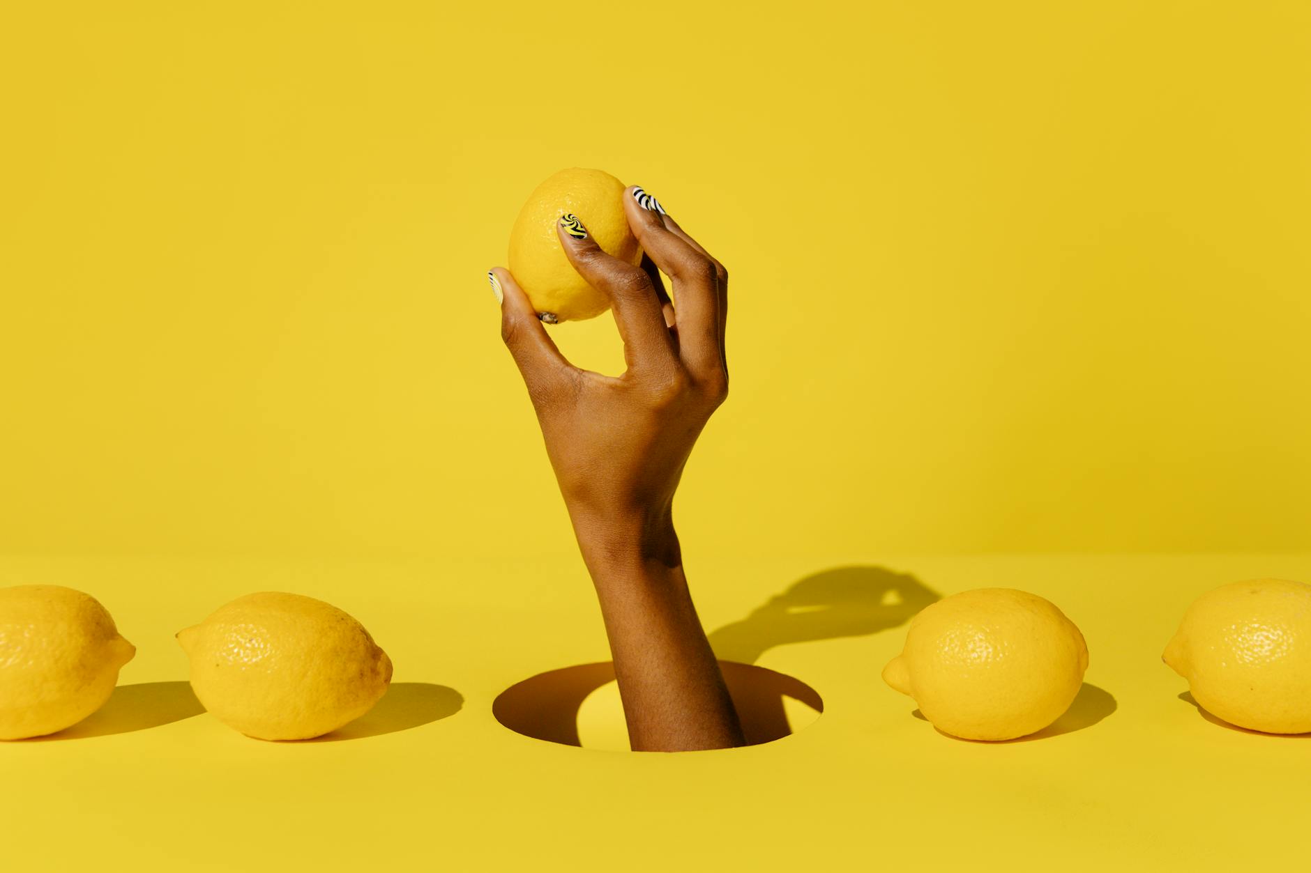 Frische gelbe Zitronen auf pastelfarbenem grünem Hintergrund, symbolisierend Frische und optimale Bedingungen für Vergnügen