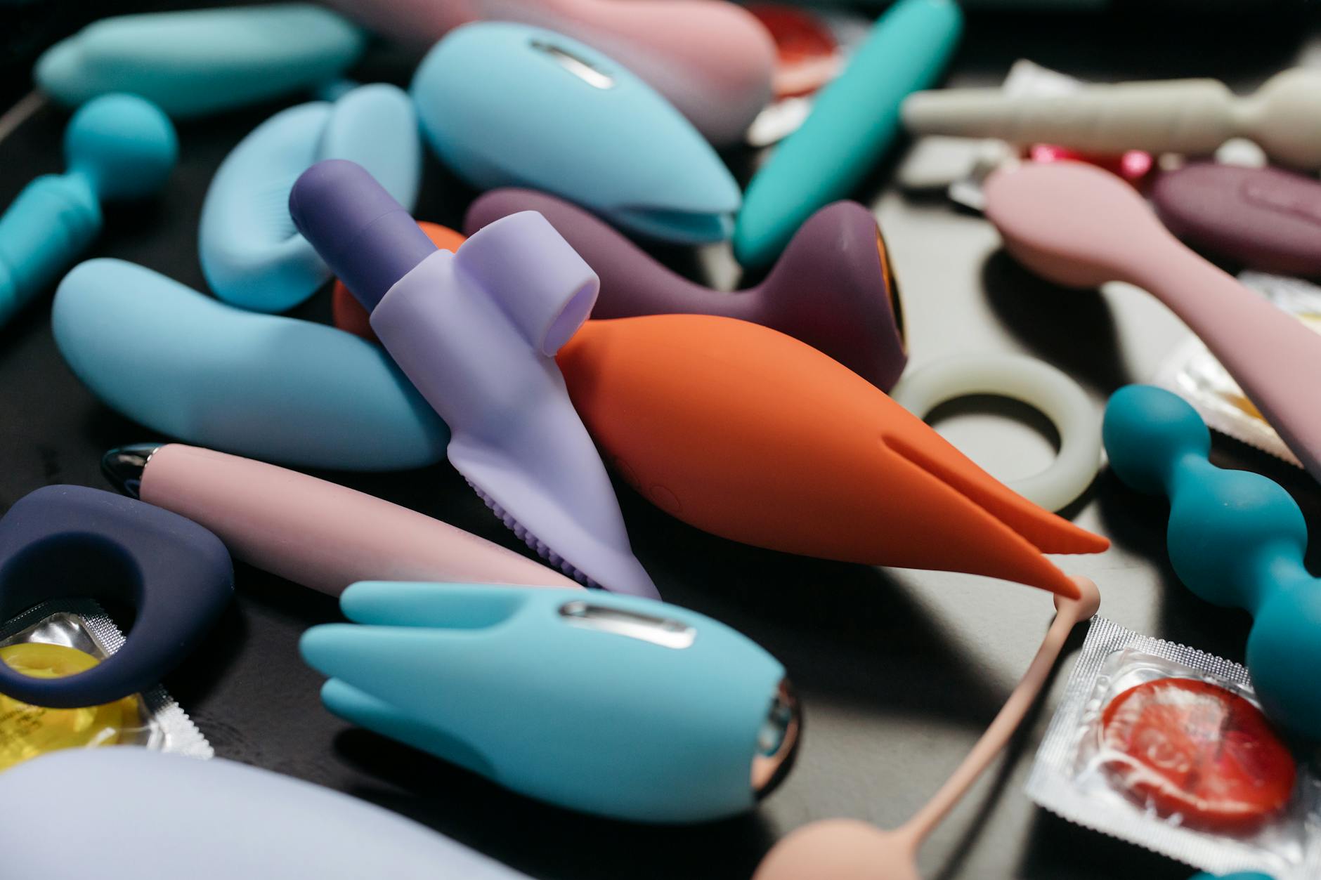 Close-up of a hand holding a lemon-colored vibrator against a minimalist purple backdrop, emphasizing modern sensuality and intimacy.
