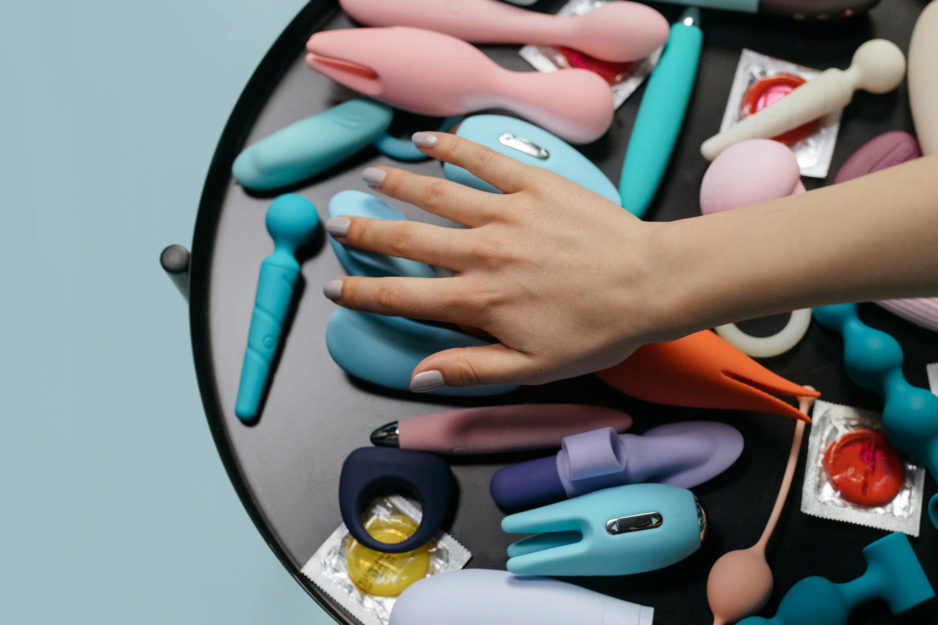 Frau mit Brille, die einen blauen Silikonvibrator in der Hand hält