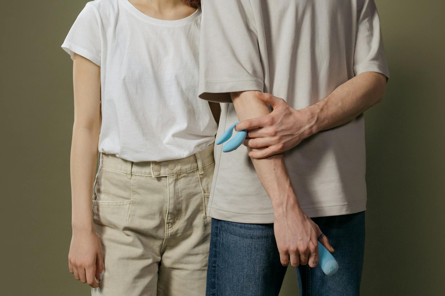 A couple standing together indoors, exploring intimacy with modern pleasure tools.